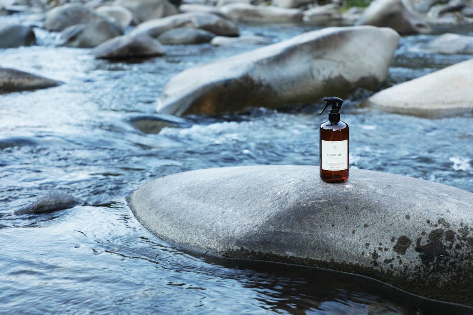 Spray bottle positioned on river rock in natural Chilean landscape.