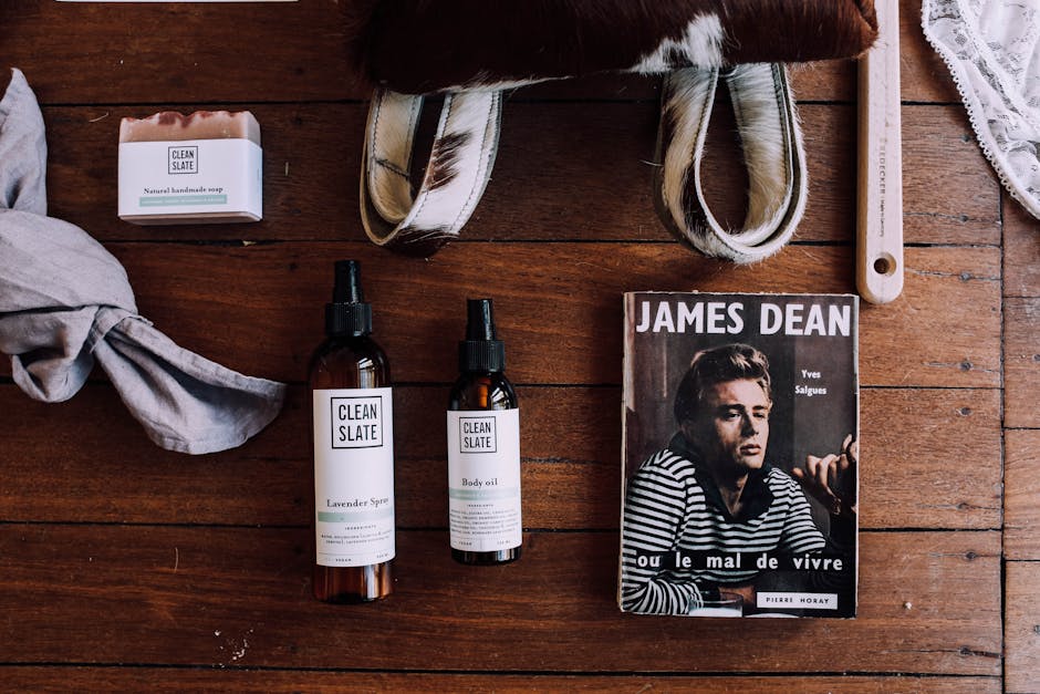 Flatlay of natural beauty products, a magazine, and accessories arranged on a wooden surface.