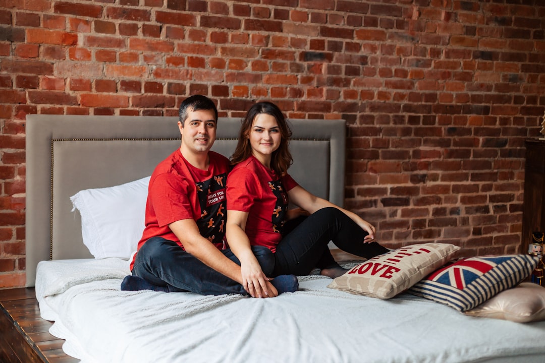 a man and a woman sitting on a bed