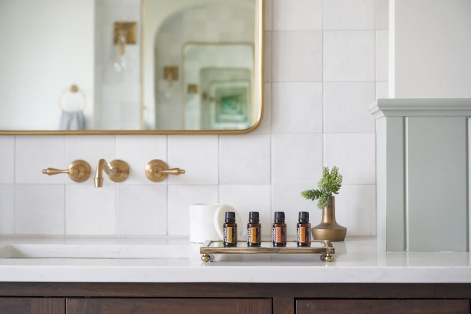 Stylish bathroom counter featuring essential oils with a mirror and minimalist design.