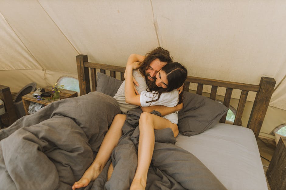 Happy couple embracing in a cozy tent, conveying love and togetherness.
