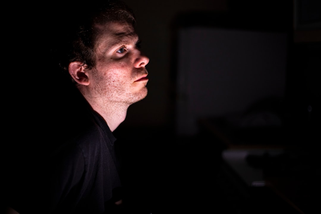a man in a dark room looking up at something
