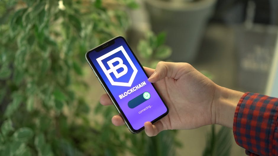 Close-up of a smartphone showing a blockchain app screen held by a hand.