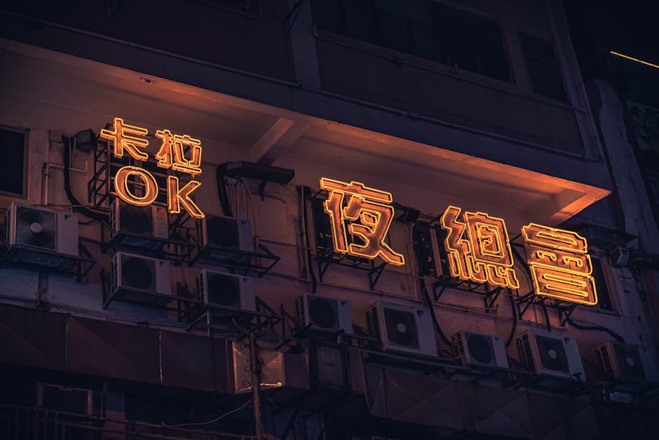 Illuminated neon signage on a Hong Kong building facade, capturing urban nightlife aesthetics.