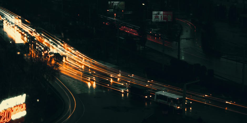 Long exposure of city highway showcasing vibrant light trails and traffic movement.
