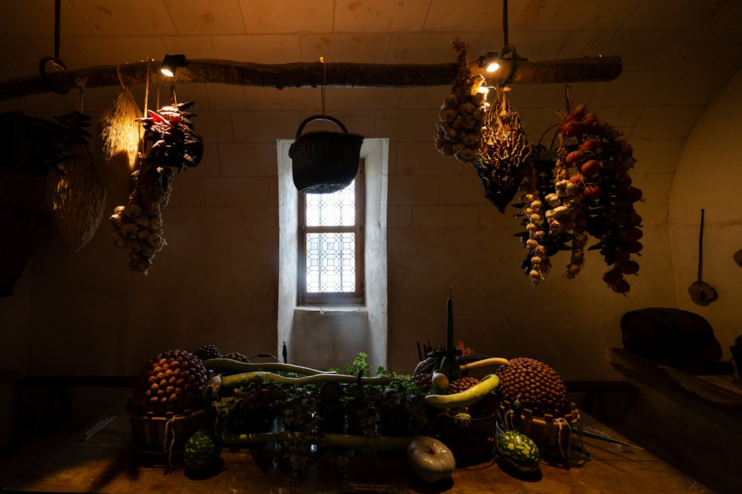 Dried herbs and fruits hang above a table of produce.