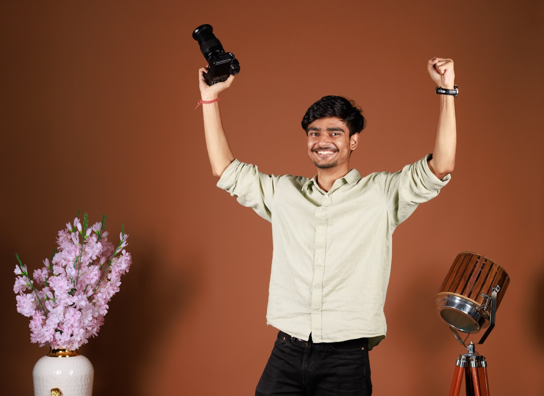 a man holding up two cell phones in the air