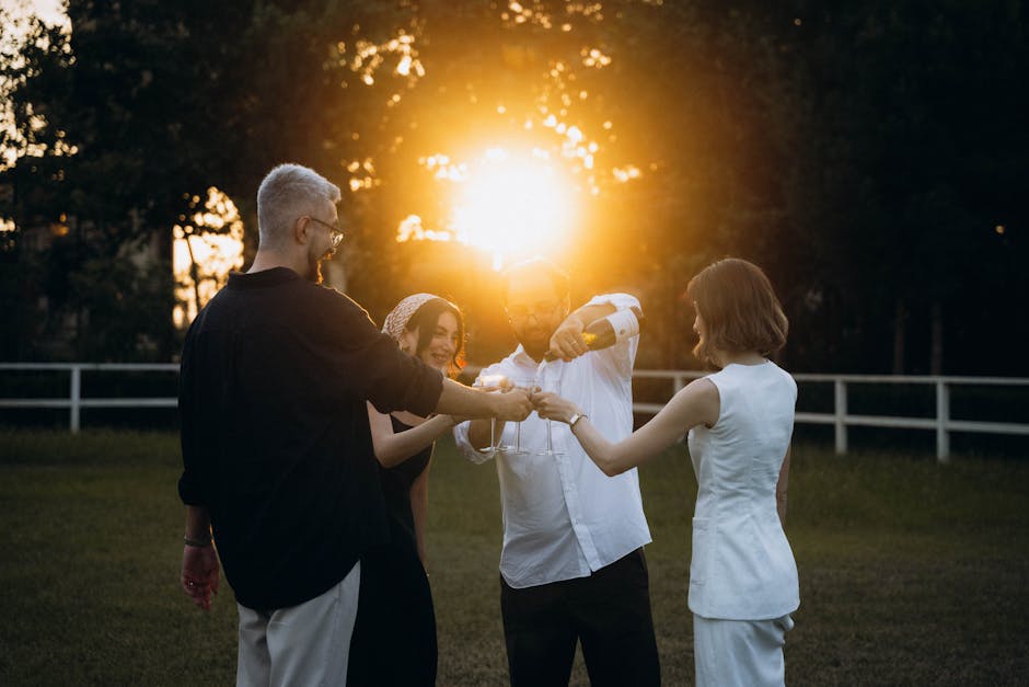 Friends enjoying a joyful outdoor celebration at sunset with toasts under the warm sun.