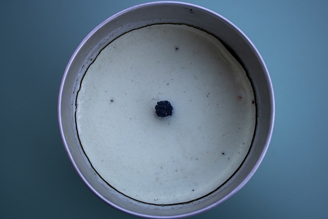 A single black blueberry in creamy white yogurt.