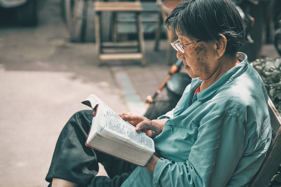 Senior man reading a book outdoors in Beijing, conveying a peaceful and studious atmosphere.