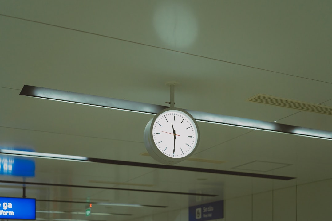 A clock hanging from the ceiling of an airport