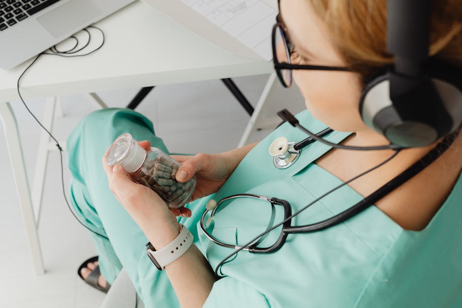 Healthcare worker in scrubs holding pills during an online consultation.